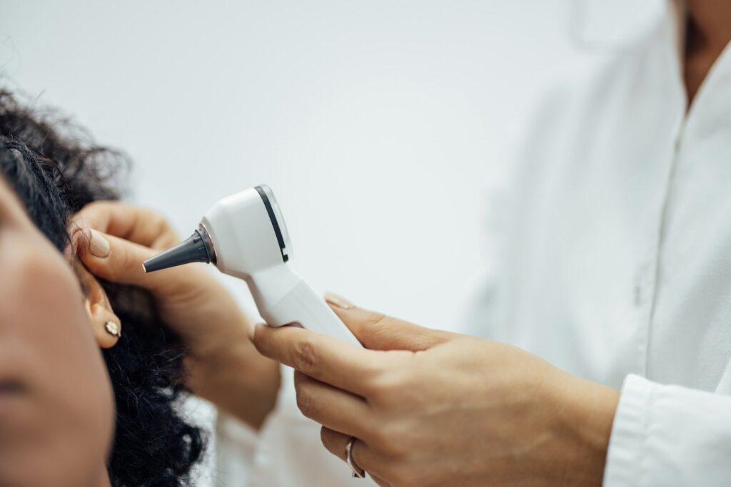 Ear examination with medical otoscope.