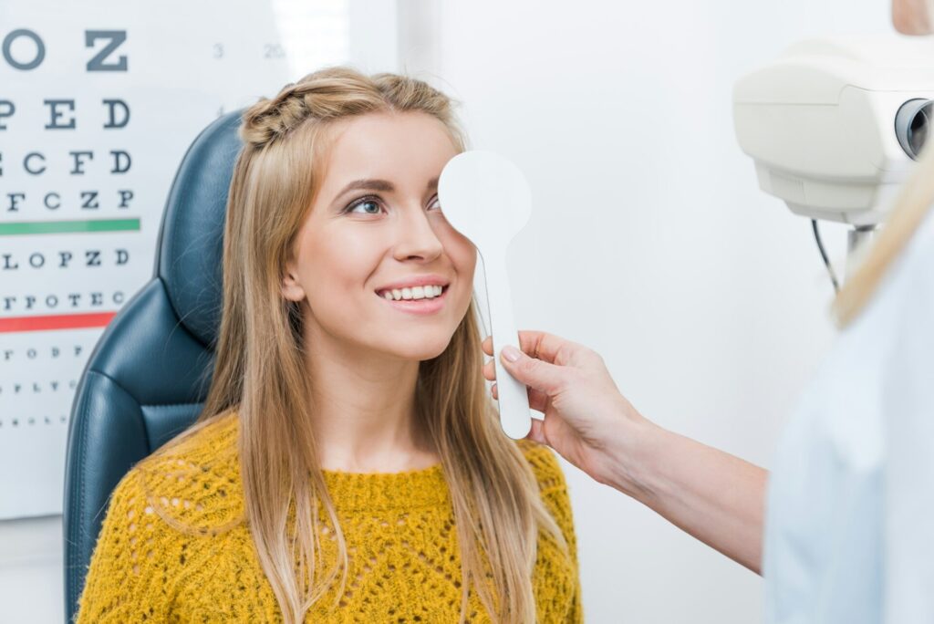 oculist examining beautiful young patient in clinic